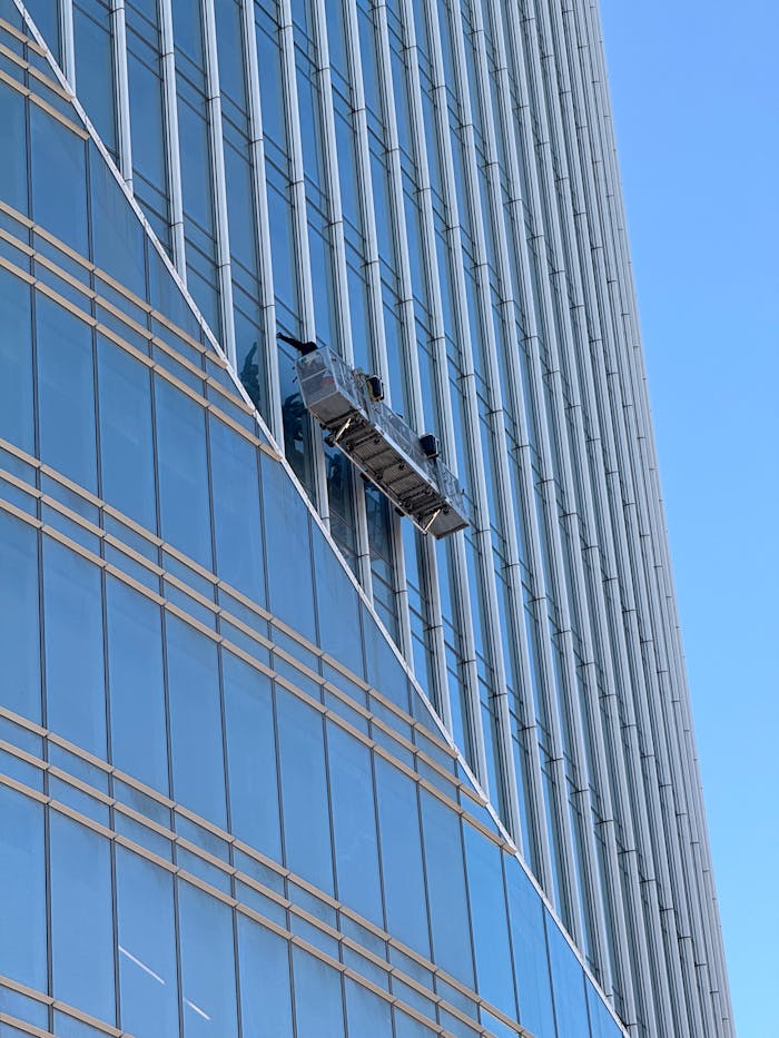 about-01 Professional window cleaners suspended on a high-rise building facade.